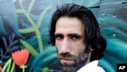 FILE - In this Nov. 19, 2019, photo, Behrouz Boochani, the Kurdish filmmaker, writer and refugee who has documented life inside the Australian offshore immigration camp on Manus Island, poses for a portrait in Christchurch, New Zealand. 