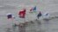 In this photo provided by Olympictorch2014.com torch bearer Alexander Brylin, with other ice swimmers, swims with Olympic torch during the torch relay in the Amur River in Blagoveshchensk, Russia's Far East.