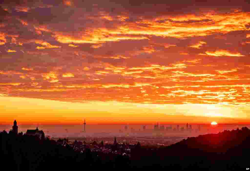 Colorful clouds are seen as the sun rises over the city of Kronberg and the bank buildings in Frankfurt, Germany, Dec. 20, 2019. 