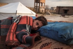 A Syrian child, one of those who fled from Idlib prvoince, sleeps in the open at a camp for the displaced near the town of Dana, Dec. 27, 2019.