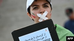 خانمێک کە لە خۆپیشاندانەکانی واشنتن دی سی بەشدار بووە لە دژی پێشێلکردنی مافەکانی مرۆڤ لە ئێران