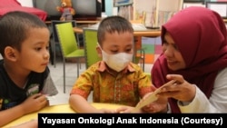 Seorang relawan Yayasan Onkologi Anak Indonesia (YOAI) bermain bersama anak-anak yang sedang menjalani perawatan kanker, September 2019. (Foto: Yayasan Onkologi Anak Indonesia)