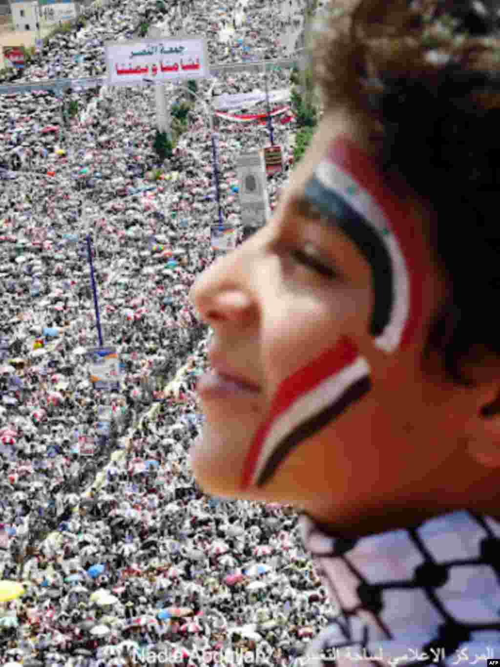 Massive crowds of demonstrators are seen behind a young protester. (Photo - Nadia Abdullah)