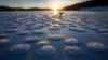 A skater observes pancakes snow on the frozen Lake des Rousses in Les Rousses, central-eastern France, Jan. 1, 2025. 