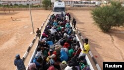 FILE - Migrants in a truck arrive at a detention center in Gharyan, Libya, Oct. 12, 2017. 