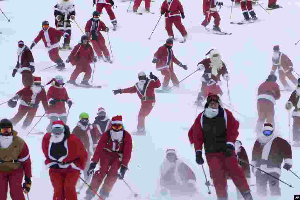 Some of the 300 skiers registered for the annual charity ski run descend the slopes at the Sunday River Ski Resort, Dec. 11, 2022, in Newry, Maine.&nbsp;