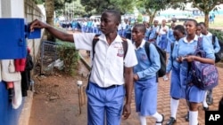 FILE - Students sign out for classes at Wampewo Ntakke Secondary School in Kawempe tula village, Kampala, Uganda, on Nov. 4, 2024. 