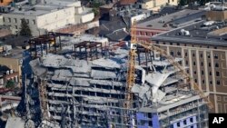 Two large cranes from the Hard Rock Hotel construction collapse are seen in this aerial photo after crashing down, after being detonated for implosion in New Orleans, Oct. 20, 2019.