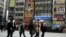 People cross a street in a business district in Tokyo, Japan.