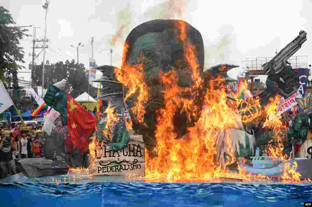 Activists burn an effigy of Philippine President Rodrigo Duterte depicted as a sea monster, during a protest near congress to coincide with Duterte&#39;s state of the nation address in Manila.