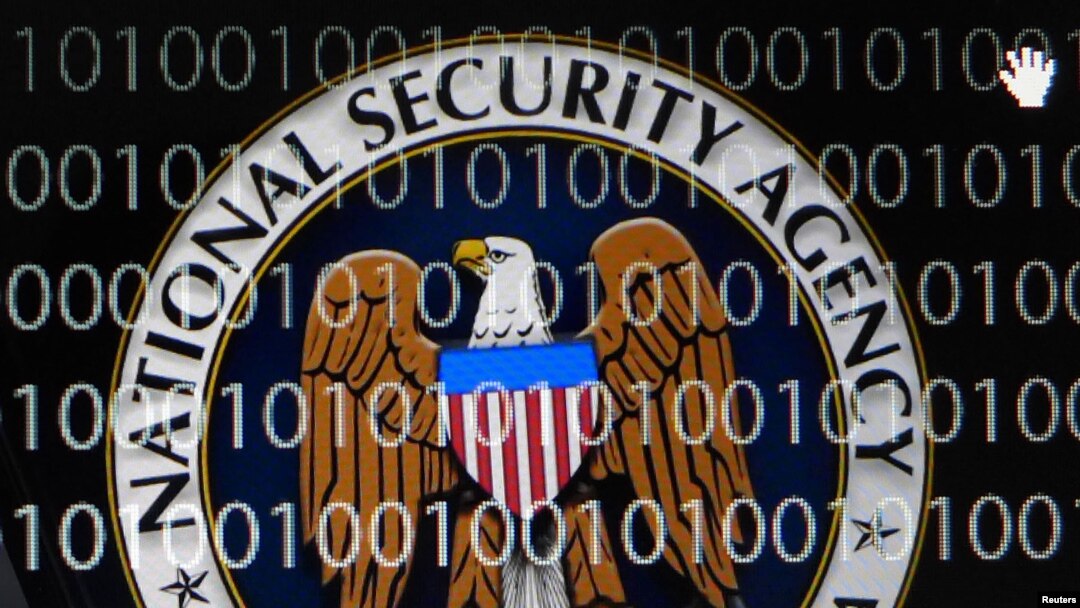 FILE - A tablet computer shows the logo of the United States' National Security Agency (NSA) against the backdrop of code in this multiple-exposure demonstration photo. 