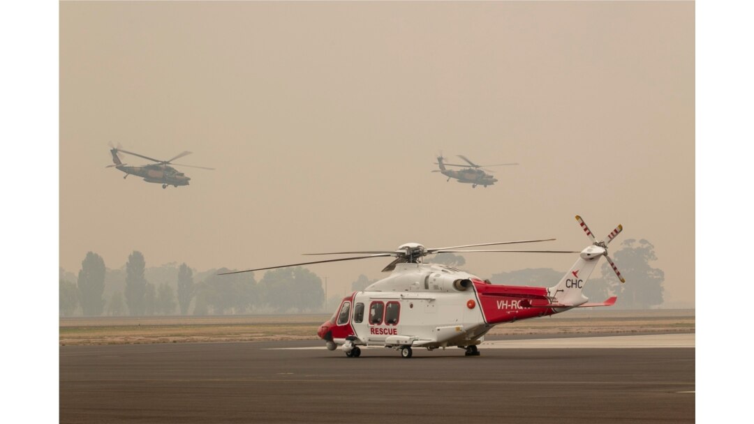 Two Australian Army Black Hawk helicopters fly through smoke at RAAF Base East Sale during bushfire relief efforts, Jan. 3, 2020.