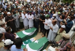 FILE - Mourners attend a funeral for some of the people who died in the crash of a state-run Pakistan International Airlines plane May 22, in Karachi, Pakistan, June 2, 2020.