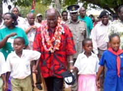 FILE - Former Zambian president Kenneth Kaunda, center, walks with children in Ganze village.