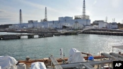 A US military barge carrying pure water (bottom) leaves the quay near Tokyo Electric Power Co.'s Fukushima Daiichi Nuclear Power Plant on April 4, 2011.