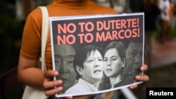 Seorang demonstran memegang poster saat protes pencalonan presiden Ferdinand “Bongbong” Marcos Jr., putra mendiang diktator Ferdinand Marcos, di Komisi Hak Asasi Manusia, di Kota Quezon, Metro Manila, Filipina, 6 Oktober 2021 (Foto: Reuters)