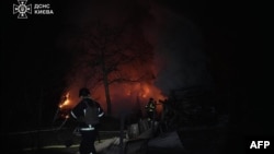 FILE - This handout photograph taken by Ukrainian State Emergency Service and released on Feb. 23, 2025, shows firefighters working to extinguish a fire at the site following a massive drone attack, in Kyiv, amid the Russian invasion of Ukraine.