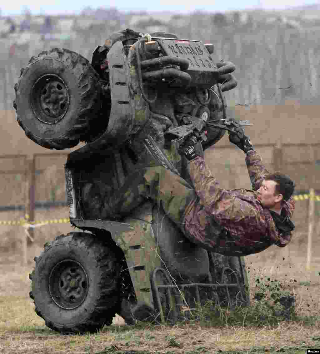 Seorang pengendara melakukan atraksi sebelum lomba balap &quot;off road&quot; di Kozhany, kawasan Siberia, Rusia.