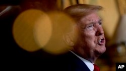 President Donald Trump speaks to members of the media following a Christmas Eve video teleconference with members of the military at his Mar-a-Lago estate in Palm Beach, Fla., Dec. 24, 2019.