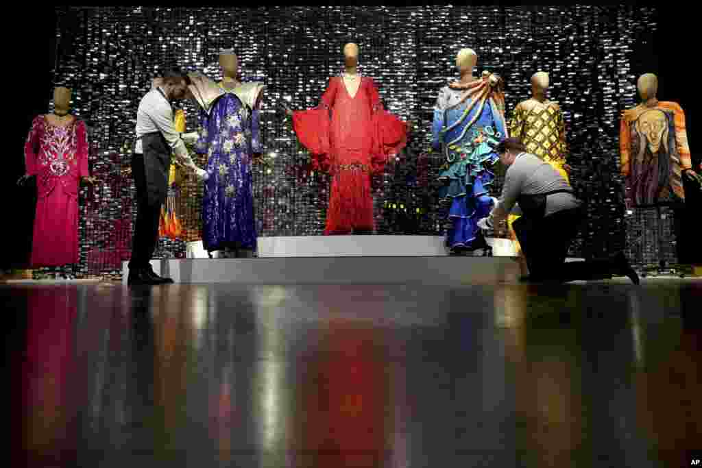 Art handlers arrange costumes during a photo opportunity ahead of the Barry Humphries: The Personal Collection sale at Christie&#39;s auction rooms in London.&nbsp;Items belonging to the late Australian comedian are to be auctioned Feb. 13 in a sale estimated at 2 million to 4 million pounds ($2.49 million to $4.98 million).