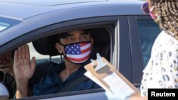 Nuevos cIudadanos estadounidenses en Santa Ana, California, juramentan desde su auto, acogiéndose a las medidas preventivas de COVID-19.