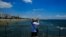 A tourist takes photos the view from the sea in southeast coast city of Larnaca in the eastern Mediterranean island of Cyprus, June 1, 2021. 
