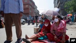 Nepalese people take refuge on a street after an earthquake hit Kathmandu, Nepal, Tuesday, May 12, 2015. A major earthquake hit Nepal in a remote region near the Chinese border on Tuesday, less than three weeks after the country was ravaged by another deadly quake. (AP Photo/Bikram Rai)