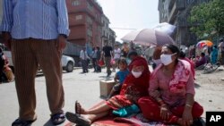 Mujeres nepalesas se colocan en el centro de una calle durante el terremoto de este martes en Bhaktapur, Nepal.