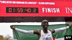 엘루이드 킵초게 선수가 마라톤 2시간 벽을 깬 뒤 케냐 국기를 들고 기뻐하고 있다.