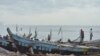 Fishermen in the Nungua area of Accra wait for canoes to come in with their catches. (S. Knott for VOA)