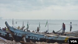 Fishermen in the Nungua area of Accra wait for canoes to come in with their catches. (S. Knott for VOA)