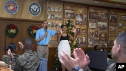 Presiden Amerika Barack Obama dan ibu negara Michelle Obama disambut meriah oleh para anggota dan keluarga militer AS di Anderson Hall, Pangkalan Angkatan Laut di Kaneohe, Hawaii , 25 Desember 2012. (AP Photo/Carolyn Kaster). Presiden Obama akan mempersingkat liburannya dan diperkirakan akan tiba kembali di Washington, Kamis pagi (27/12).