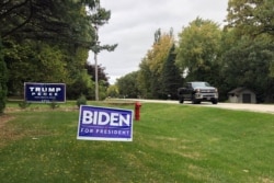 Signs for Democratic presidential candidate former Vice President Joe Biden and President Donald Trump mark neighboring properties in a middle-class neighborhood of Oshkosh, Wisconsin, Sept. 29, 2020.