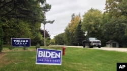FILE - Signs for Democratic presidential candidate former Vice President Joe Biden and President Donald Trump mark neighboring properties in a middle-class neighborhood of Oshkosh, Wisconsin, Sept. 29, 2020. 