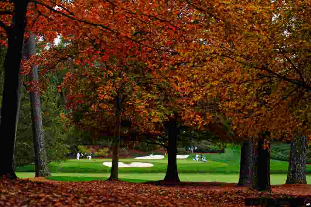 Rory McIlroy of Ireland, Phil Mickelson, Dustin Johnson and Xander Schaufele line up their putts on the 12th green during a practice round for the Masters golf tournament in Augusta, Georgia, USA.