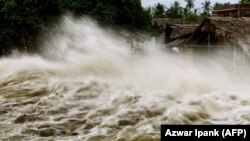 Gelombang pasang meluap ke desa nelayan yang rusak di dekat pantai Ujong Blang di Lhokseumawe, Aceh pada 27 Mei 2021 sebagai ilustrasi. BMKG mengeluarkan peringatan dini munculnya bibit siklon tropis di Laut Timor. i(Foto: AFP/Azwar Ipank)