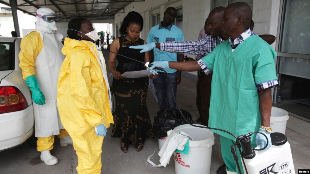 FILE - A health worker sprays a colleague with disinfectant during a training session for Congolese health workers to deal with Ebola virus in Kinshasa, Oct. 21, 2014. The Democratic Republic of Congo had declared a two-month ebola outbreak over.