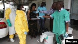 FILE - A health worker sprays a colleague with disinfectant during a training session for Congolese health workers to deal with Ebola virus in Kinshasa, Oct. 21, 2014. The Democratic Republic of Congo had declared a two-month ebola outbreak over.