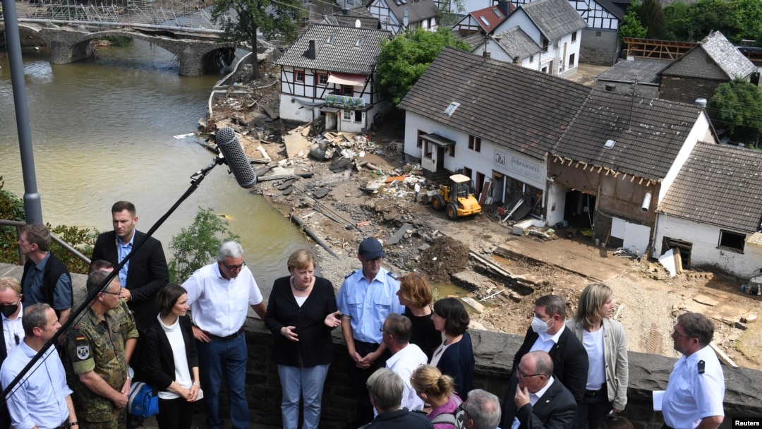 Kanselir Jerman Angela Merkel dan pemimpin negara bagian Rhineland-Palatinate, Malu Dreyer, berbincang dengan warga saat mengunjungi wilayah yang diterjang banjir di negara bagian itu, Minggu, 18 Juli 2021. (Foto: Christof Stache Pool/via Reuters)