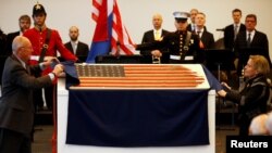 Netherland's Minister of Defence Ank Bijleveld-Schouten and U.S. ambassador Pete Hoekstra (L) unveil an American flag that led the US invasion fleet at Normandy's Utah Beach is displayed during the 75th anniversary of the D-Day flag in Rotterdam, Netherlands, Feb. 4, 2019.