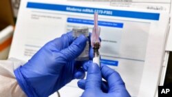 FILE - A nurse prepares a shot as the world's biggest study of a possible COVID-19 vaccine, developed by the National Institutes of Health and Moderna Inc., gets under way in Binghamton, N.Y., July 27, 2020.