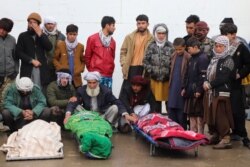 FILE - Afghans attend funeral of the family members of journalist Bismillah Adil Aimaq, who was shot dead in an unclaimed attack nearby Ghor on Jan. 1, in in Ghor, western Afghanistan, Feb. 26, 2021.