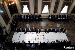 FILE - U.S. Trade Representative Robert Lighthizer, Treasury Secretary Steven Mnuchin and other U.S. officials gather with China's Vice Premier Liu He and other Chinese officials before the start of trade talks in Washington, Feb. 21, 2019.