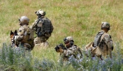 FILE - Members of the German army's special forces secure an area while demonstrating their skills in training in Claw, near Stuttgart, July 14, 2014.