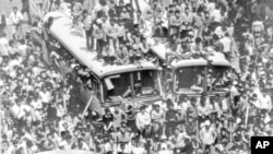 ARCHIVO - Autobuses urbanos requisados son utilizados para bloquear una calle principal del centro de Gwangju (Kwangju), el 23 de mayo de 1980, por manifestantes contra la policía antidisturbios y los paracaidistas durante tumultuosas protestas antigubernamentales.