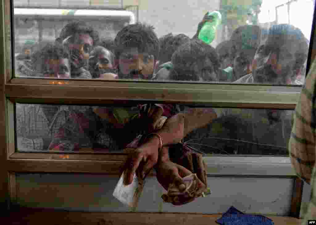 Laborers buy bus tickets at a counter of Jammu and Kashmir Tourist Reception Centre (JKTRC) in Srinagar, India. Kashmir remained in a state of heightened security to prevent protests.