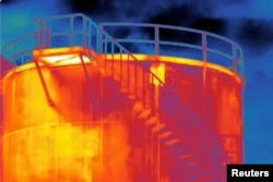 FILE - A screen grab from thermographic video footage shot with an infrared camera on June 10, 2021 shows what appears to be methane gas leaking from a rusty hole (small yellow rectangular section) on the side of a storage tank at the Eni gas plant near Pineto, Italy.