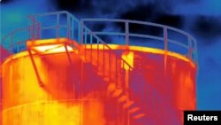 FILE - A screen grab from thermographic footage shot with an infrared camera on June 10, 2021 by Clean Air Task Force, shows methane gas leaking from a rusty hole (small yellow rectangular section) on the side of a storage tank at the Eni gas plant near Pineto, Italy.