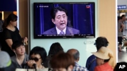 韩国人观看电视报道日本首相安倍就二战结束70周年发表谈话（2015年8月14日）