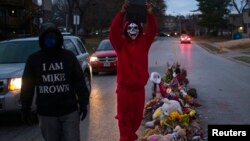 Dos individuos caminan en el lugar donde murió el joven Michael Brown en Ferguson, Missouri.